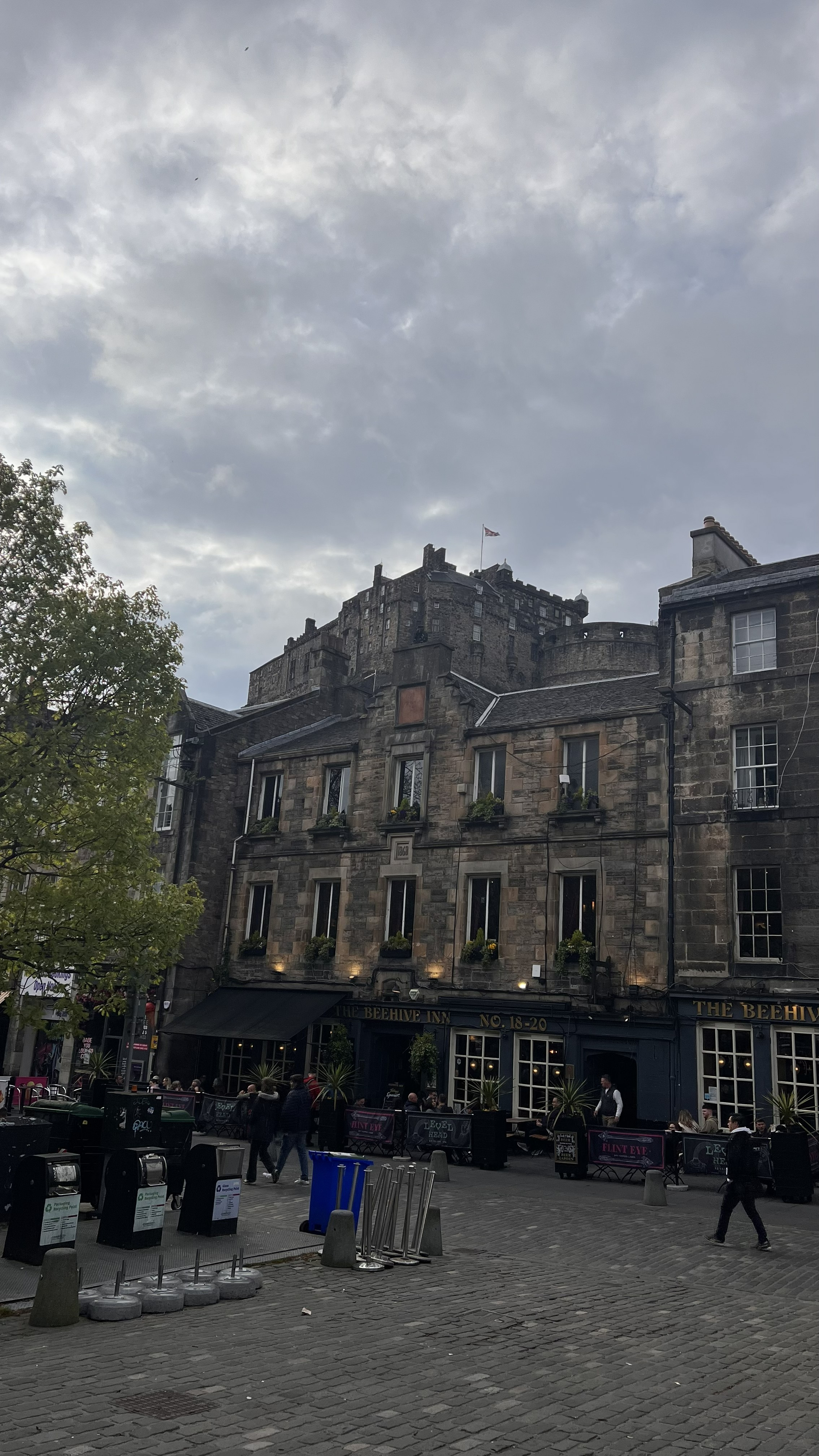 Grassmarket en Edinburgh al atardecer, plaza histórica rodeada de pubs con el castillo al fondo